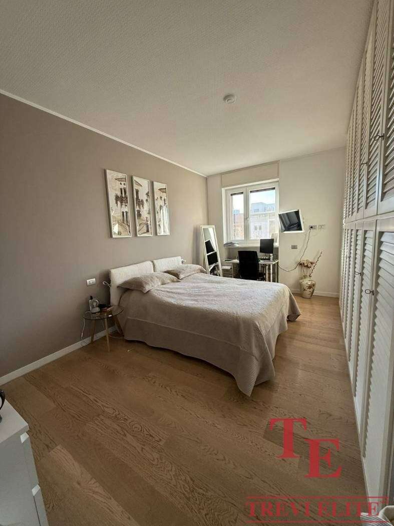 Современная роскошная спальня в элитной квартире с уютным интерьером и видом на город. Идеальное решение для ценителей высокого комфорта и эксклюзивной недвижимости.