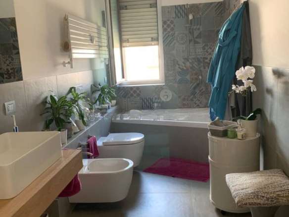 современная уютная ванная комната в стильном дизайне, светлые тона, окна с хорошим освещением, зеленые растения, аккуратная мебель, предметы для комфорта и уюта, отличное предложение элитной недвижимости.