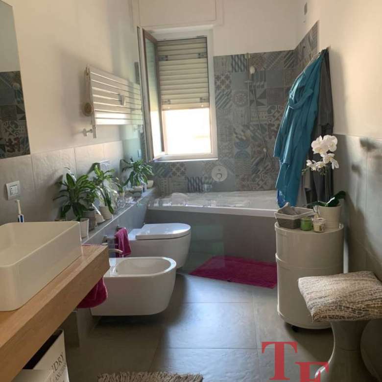 современная уютная ванная комната в стильном дизайне, светлые тона, окна с хорошим освещением, зеленые растения, аккуратная мебель, предметы для комфорта и уюта, отличное предложение элитной недвижимости.