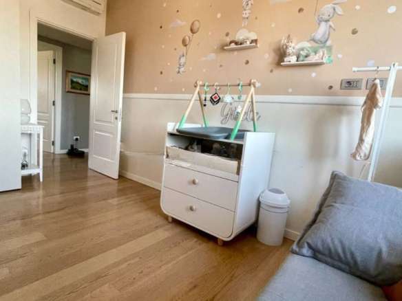 Красивая детская комната с детской кроваткой, декором в стиле зайчиков и мягкими игрушками на стенах, создает уютную атмосферу для малыша. Идеальное место для отдыха и игры ребенка.