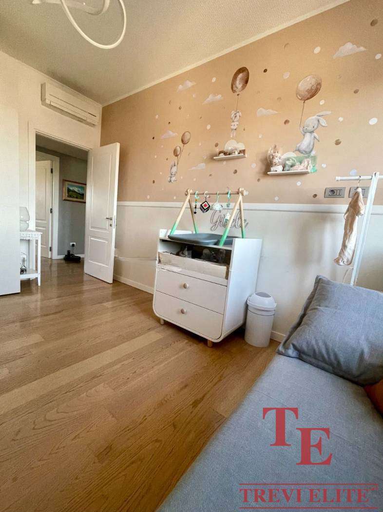 Красивая детская комната с детской кроваткой, декором в стиле зайчиков и мягкими игрушками на стенах, создает уютную атмосферу для малыша. Идеальное место для отдыха и игры ребенка.