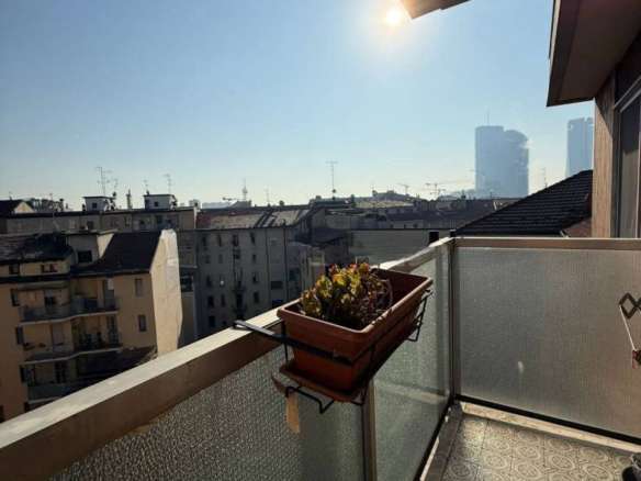 Уютный балкон с видом на город, солнечный свет, современные здания, просторное пространство, идеальное место для отдыха и наслаждения видами в Москве.