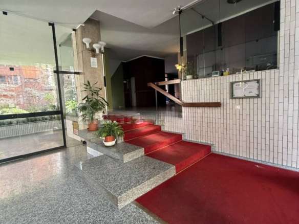 Современный вход в элитное офисное здание, интерьеры с мраморной отделкой, уютные растения и удобные ступени, идеально подходящий для клиентов агентства недвижимости.