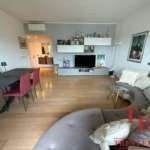 Современная гостиной с мягким диваном, телевизором и стильной мебелью, в интерьере преобладают светлые тона, что создает уютную атмосферу для комфортного отдыха.