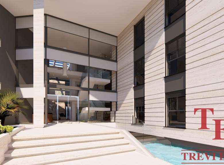 Элитное современное жилое здание с просторным входом и зоной отдыха на открытом воздухе в стиле люкс.