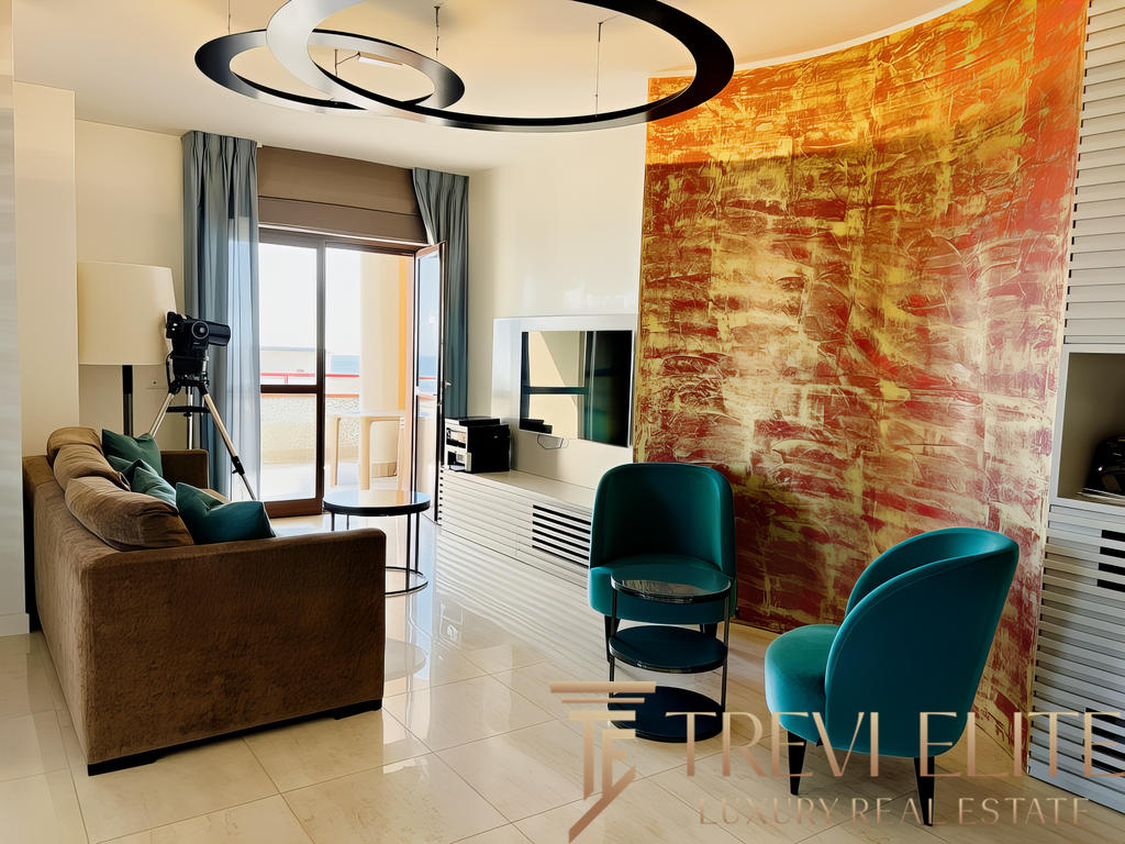 Современная гостиная с яркой декоративной стеной, уютным диваном, креслами и балконом, наполняющим пространство естественным светом. Идеальное место для отдыха и просмотра телевизора.