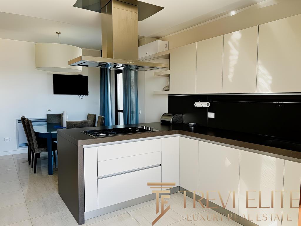 Современная уютная кухня в элитной квартире с светлыми фасадами и стильной черной столешницей. Чистый дизайн и функциональность, идеально для комфортной жизни.