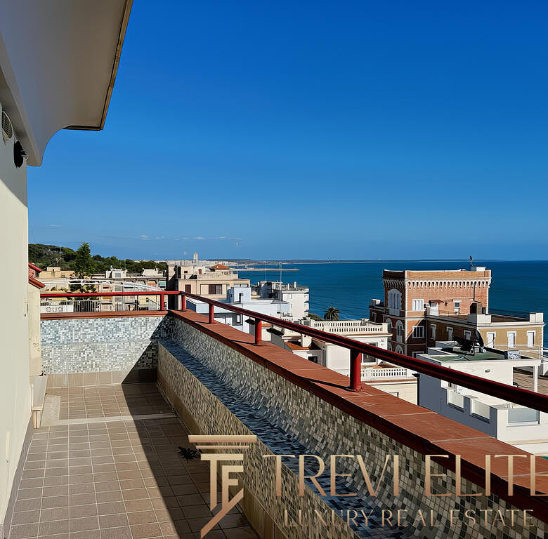 Обзор видового балкона с морским пейзажем на фоне современного жилого комплекса вдоль побережья.