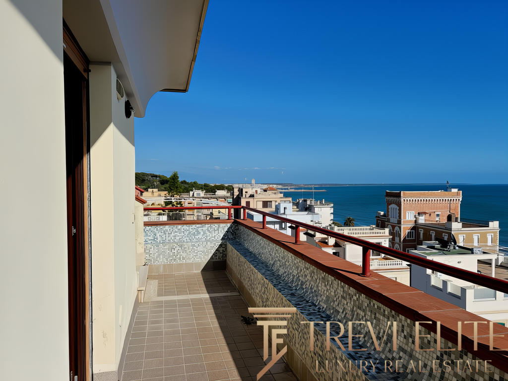 Обзор видового балкона с морским пейзажем на фоне современного жилого комплекса вдоль побережья.