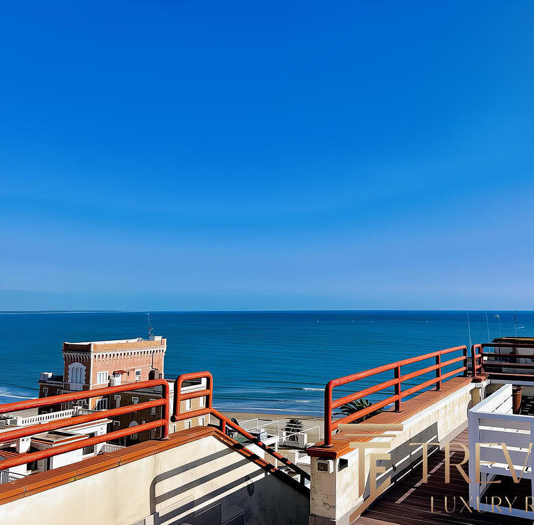 Вид на морской пейзаж с террасы на крыше современного жилого комплекса на берегу моря. Яркое солнечное небо, голубое море и уютная зона отдыха с комфортной мебелью.
