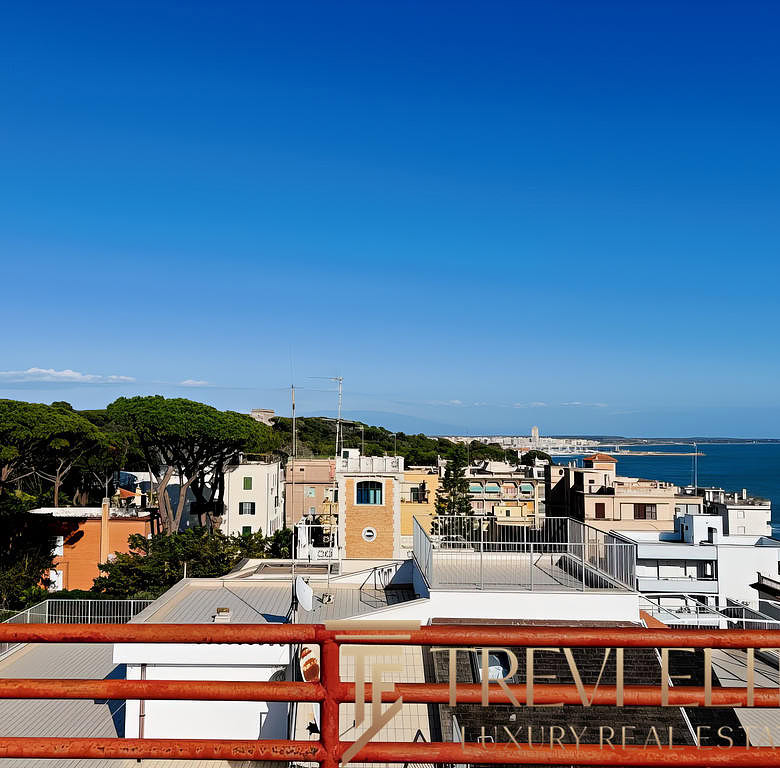 Современный вид города с балкона, море на горизонте, элитные жилые дома и зеленые насаждения. Идеальное место для тех, кто ищет престижную недвижимость у моря.