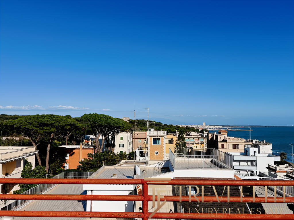 Современный вид города с балкона, море на горизонте, элитные жилые дома и зеленые насаждения. Идеальное место для тех, кто ищет престижную недвижимость у моря.