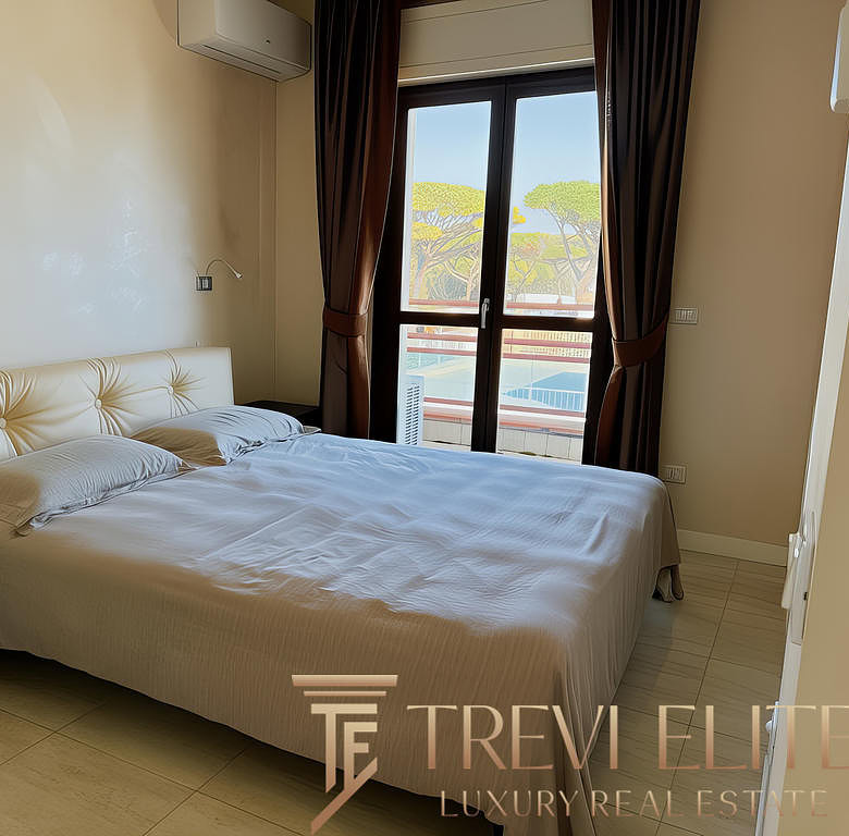 Уютная спальня с двуспальной кроватью, просторными окнами и видом на зелёные деревья, идеально подходит для комфортного отдыха и проживания в роскошном жилье от Треви Элит.