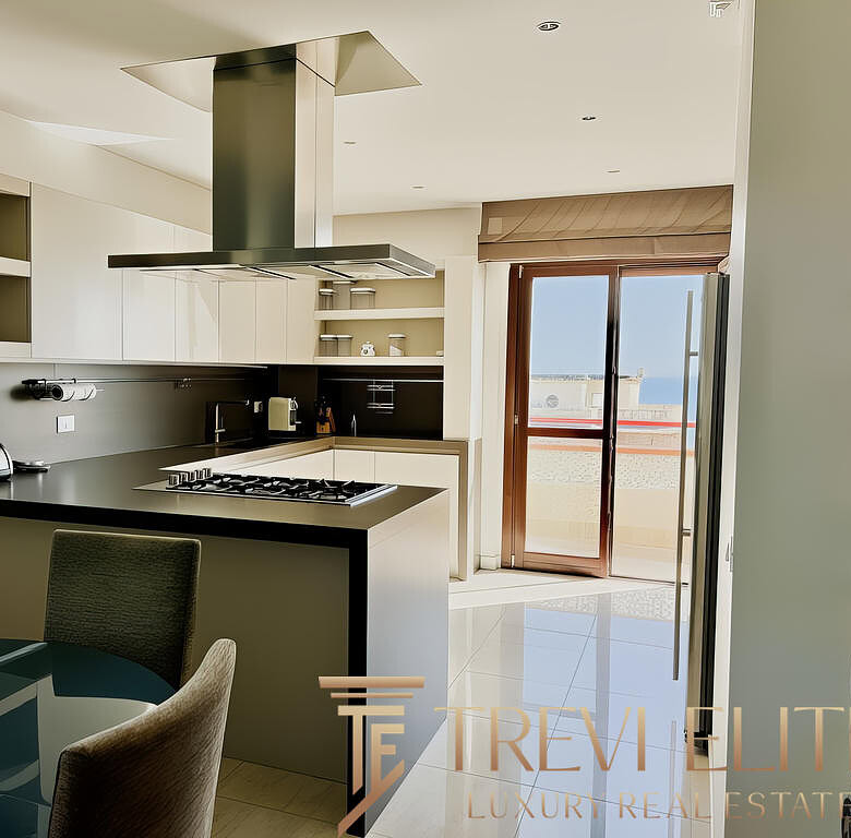 Современная кухня в светлом интерьере с балконом, просторная и оборудована техникой, идеально подходит для комфортного проживания и отдыха.