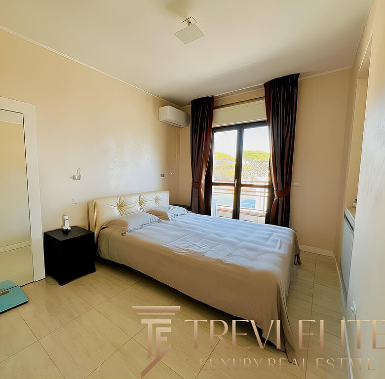 Современная спальня в элитной недвижимости с видом на balcony, уютной кроватью, просторной комнатой и стильным дизайном. Идеально подходит для роскошного жилья.