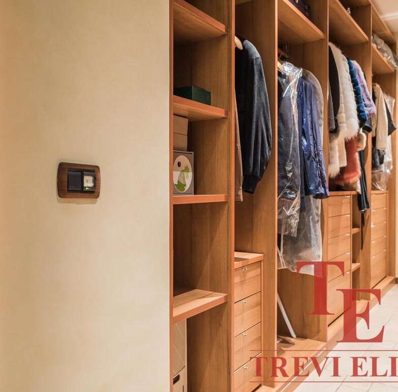 Высококачественный шкаф-гардероб с аккуратными полками и вешалками, идеально для хранения одежды и аксессуаров, в роскошной итальянской обстановке.