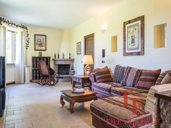 Уютная гостиная с камином, мягким диваном и стильными декоративными элементами, создающая атмосферу комфорта и роскоши в элитной недвижимости.