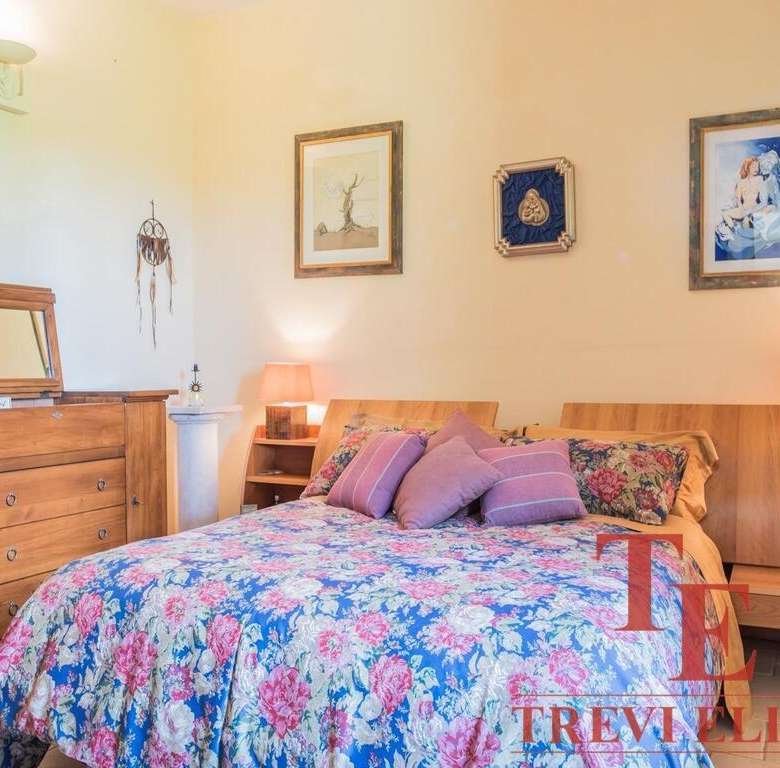 Уютная спальня с деревянной мебелью и цветочным постельным бельем в элитном итальянском особняке. Идеальное пространство для отдыха в роскошной недвижимости.