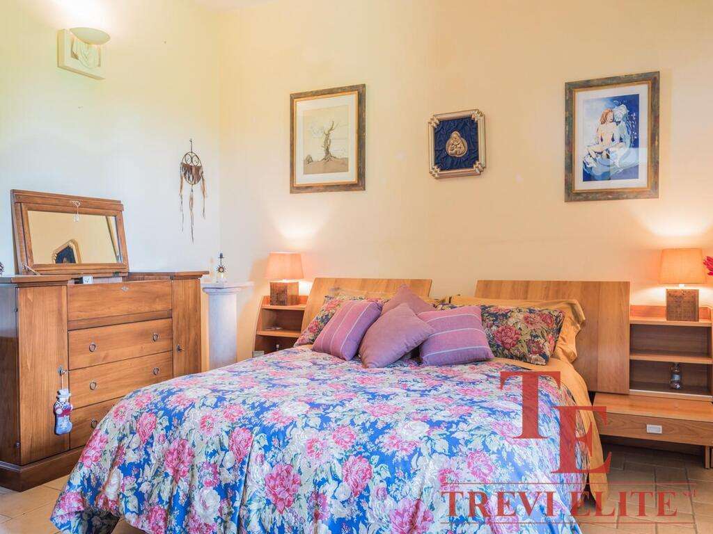 Уютная спальня с деревянной мебелью и цветочным постельным бельем в элитном итальянском особняке. Идеальное пространство для отдыха в роскошной недвижимости.