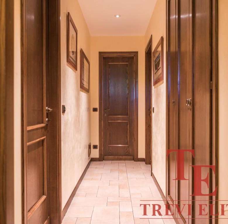 Высококачественная отделка деревянных дверей и панелей в коридоре престижного жилого комплекса. Просторный и уютный холл с теплыми тонами стен и пола. Идеальное решение для ценителей роскоши и комфорта.