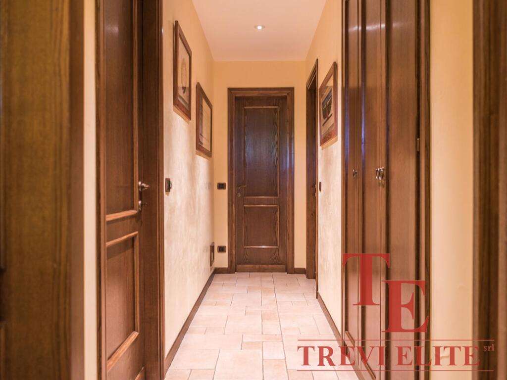 Высококачественная отделка деревянных дверей и панелей в коридоре престижного жилого комплекса. Просторный и уютный холл с теплыми тонами стен и пола. Идеальное решение для ценителей роскоши и комфорта.