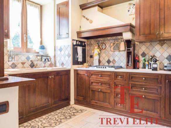 Уютная классическая кухня с деревянными фасадами, натуральным каменным фартуком и большим окном, пропускающим много естественного света. Идеально подходит для комфортного домашнего обеда.