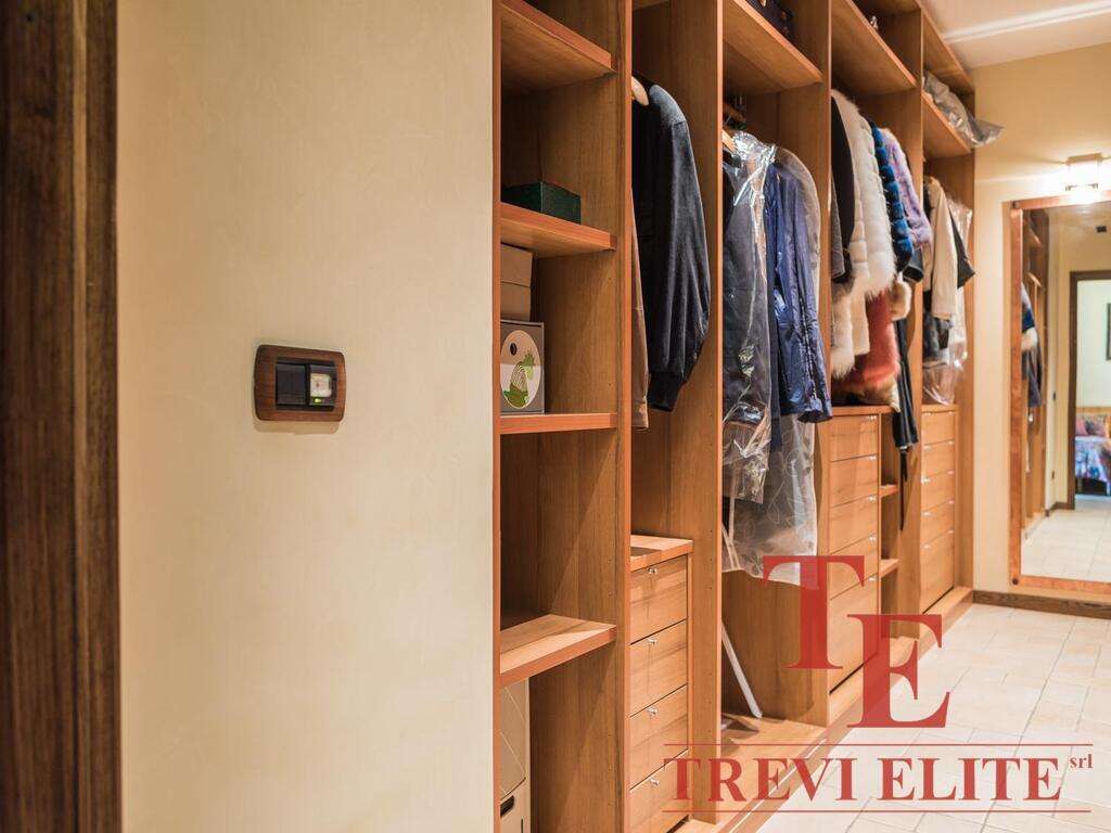 Высококачественный шкаф-гардероб с аккуратными полками и вешалками, идеально для хранения одежды и аксессуаров, в роскошной итальянской обстановке.