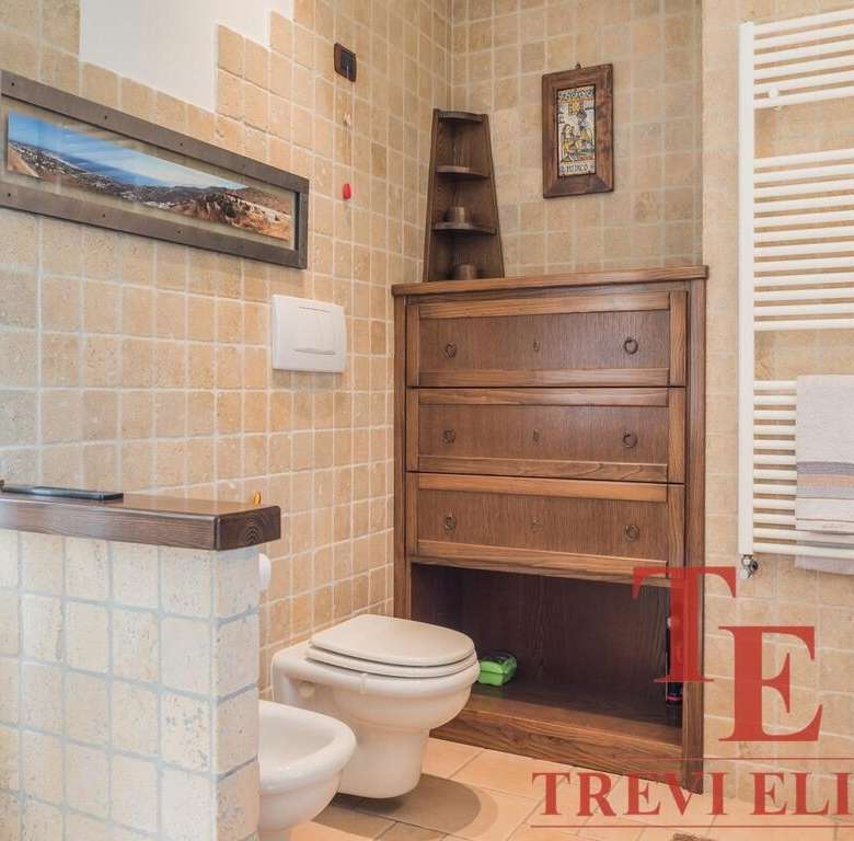 Изображение внутреннего интерьера ванной комнаты с деревянной мебелью и теплой отделкой стен.