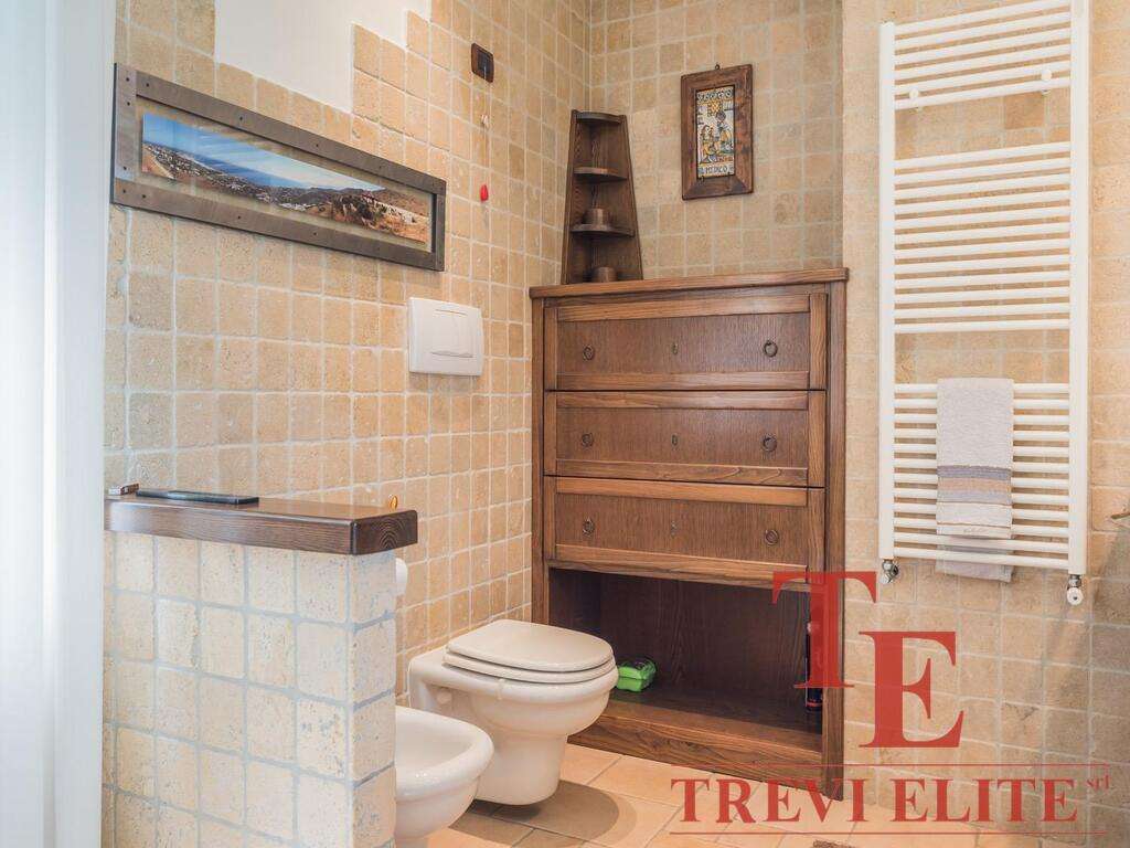 Изображение внутреннего интерьера ванной комнаты с деревянной мебелью и теплой отделкой стен.