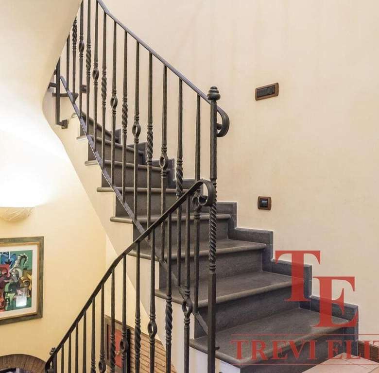 Элегантная лестница с кованым перилами в интерьере роскошного дома в Италии. Идеальный пример высококлассной недвижимости для престижных клиентов.