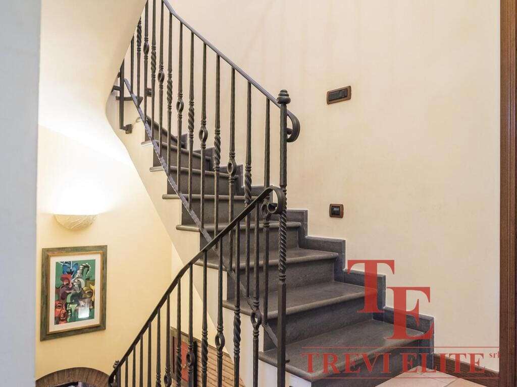 Элегантная лестница с кованым перилами в интерьере роскошного дома в Италии. Идеальный пример высококлассной недвижимости для престижных клиентов.