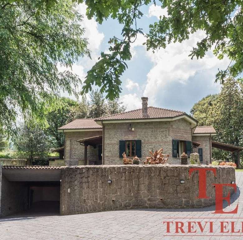 Элитный коттедж из камня на фоне зелени и голубого неба, роскошная недвижимость в Италии.