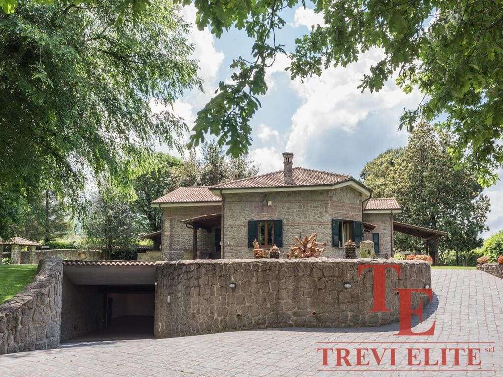 Элитный коттедж из камня на фоне зелени и голубого неба, роскошная недвижимость в Италии.