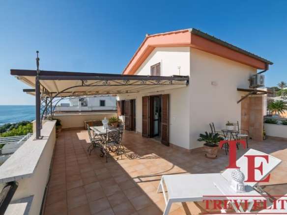 Роскошная терраса на крыше с видом на море, идеальное место для отдыха и развлечений в элитной недвижимости Италии.