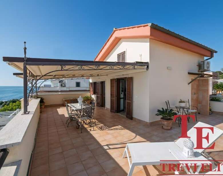 Роскошная терраса на крыше с видом на море, идеальное место для отдыха и развлечений в элитной недвижимости Италии.