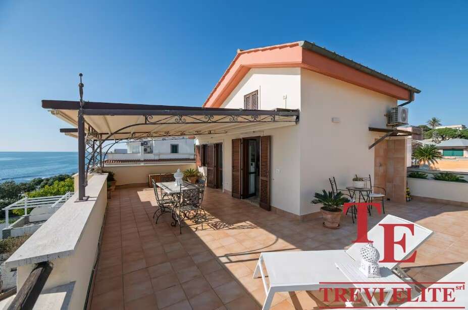 Роскошная терраса на крыше с видом на море, идеальное место для отдыха и развлечений в элитной недвижимости Италии.