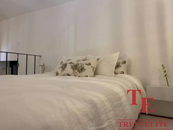 Элегантная спальня в современной квартире с минималистичным дизайном и уютной атмосферой. Идеальное пространство для отдыха и спокойствия.