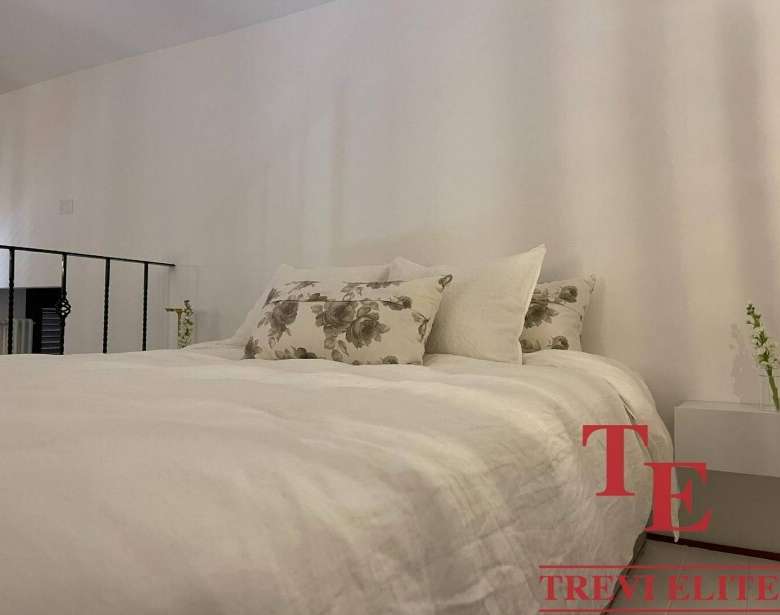 Элегантная спальня в современной квартире с минималистичным дизайном и уютной атмосферой. Идеальное пространство для отдыха и спокойствия.