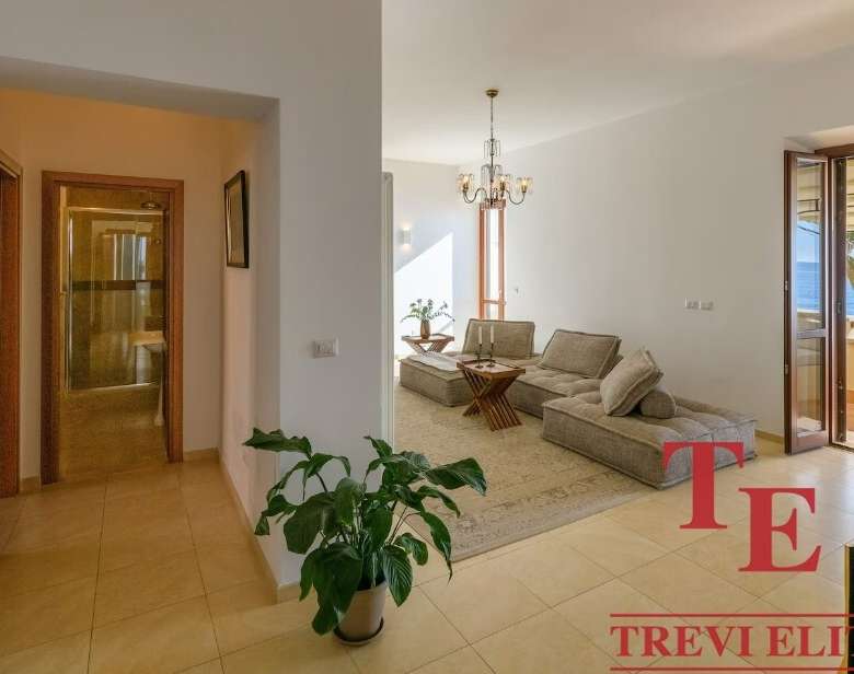 Комфортабельная гостиная с балконом и видом на море, современный дизайн, уютная обстановка, идеальное место для отдыха в роскошной недвижимости Треви Элит.