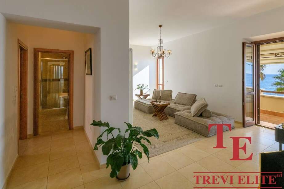 Комфортабельная гостиная с балконом и видом на море, современный дизайн, уютная обстановка, идеальное место для отдыха в роскошной недвижимости Треви Элит.