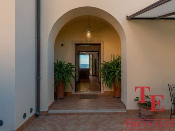 Роскошный внутренний дворик с аркой, уютным освещением и зеленью, характерный для элитной недвижимости высокого класса.