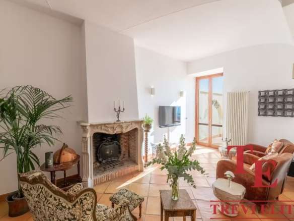 Высококлассный интерьер в современном стиле с камином и уютной зоной отдыха, большие окна пропускают естественный свет, идеальное пространство для комфорта и роскоши.