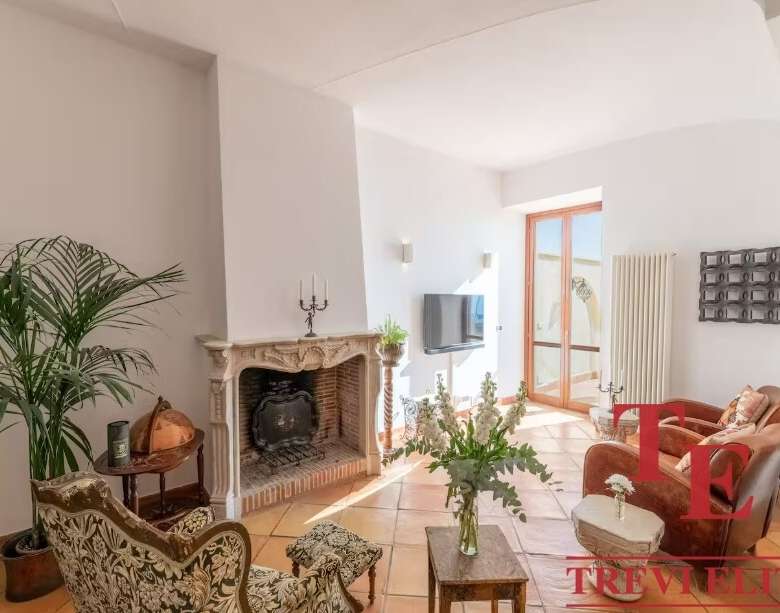 Высококлассный интерьер в современном стиле с камином и уютной зоной отдыха, большие окна пропускают естественный свет, идеальное пространство для комфорта и роскоши.