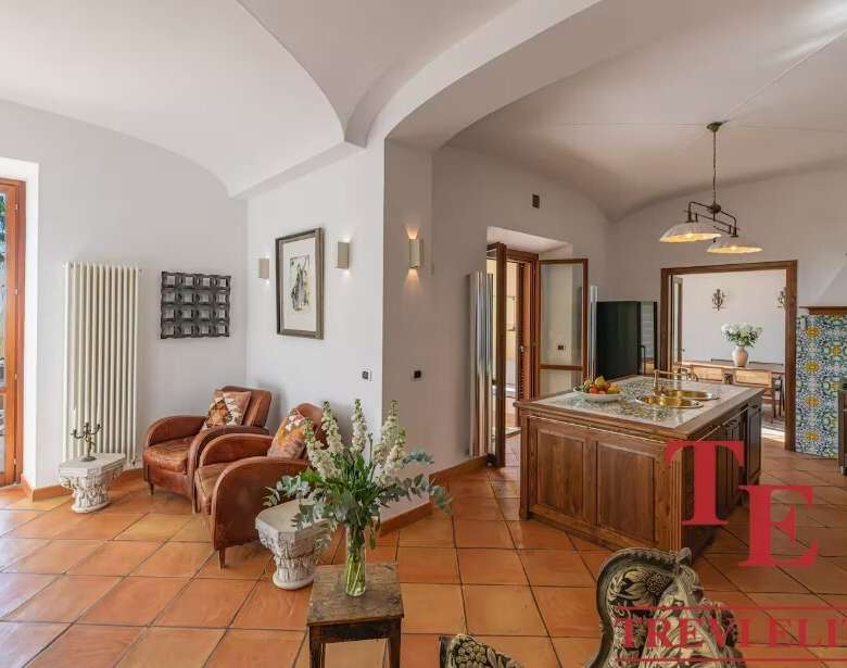 уютная гостиная с видом на море, просторная и светлая, шикарный интерьер с камином и уютной мебелью, идеальное место для отдыха в эксклюзивной недвижимости Треви Элит.