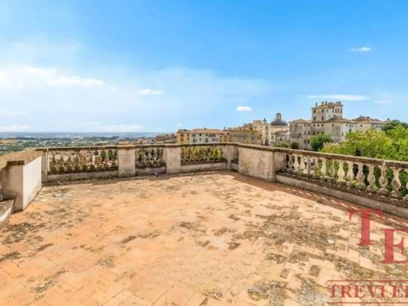 Высокий вид с террасы на старинные здания и пейзаж итальянского города, роскошное жильё для элитных покупателей в Италии.