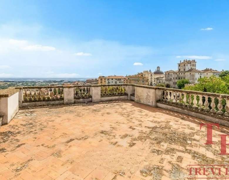 Высокий вид с террасы на старинные здания и пейзаж итальянского города, роскошное жильё для элитных покупателей в Италии.