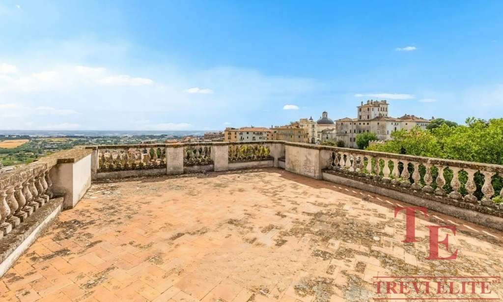 Высокий вид с террасы на старинные здания и пейзаж итальянского города, роскошное жильё для элитных покупателей в Италии.