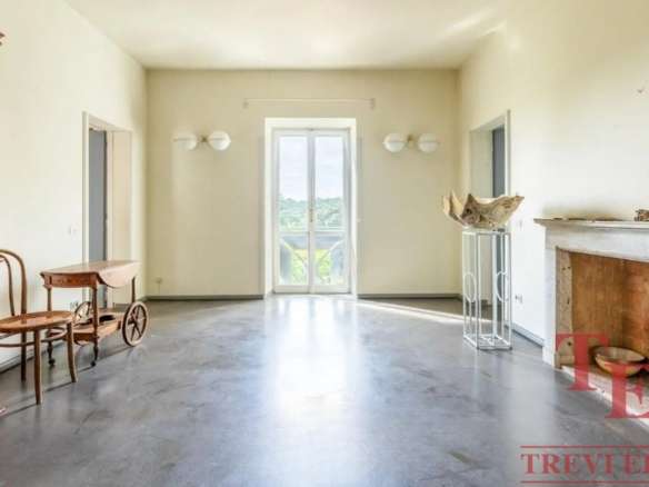 Внутренний вид комнаты с натуральной мебелью и большим окном, обеспечивающим естественное освещение и отличный вид на природу. Идеально для элитной недвижимости и престижных интерьеров.