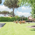 Участок с зеленой газонной территорией, садовыми деревьями и уютной атмосферой, окруженный природой для роскошного уединения и комфортной жизни.