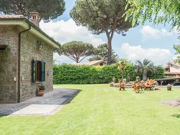 Участок с зеленой газонной территорией, садовыми деревьями и уютной атмосферой, окруженный природой для роскошного уединения и комфортной жизни.